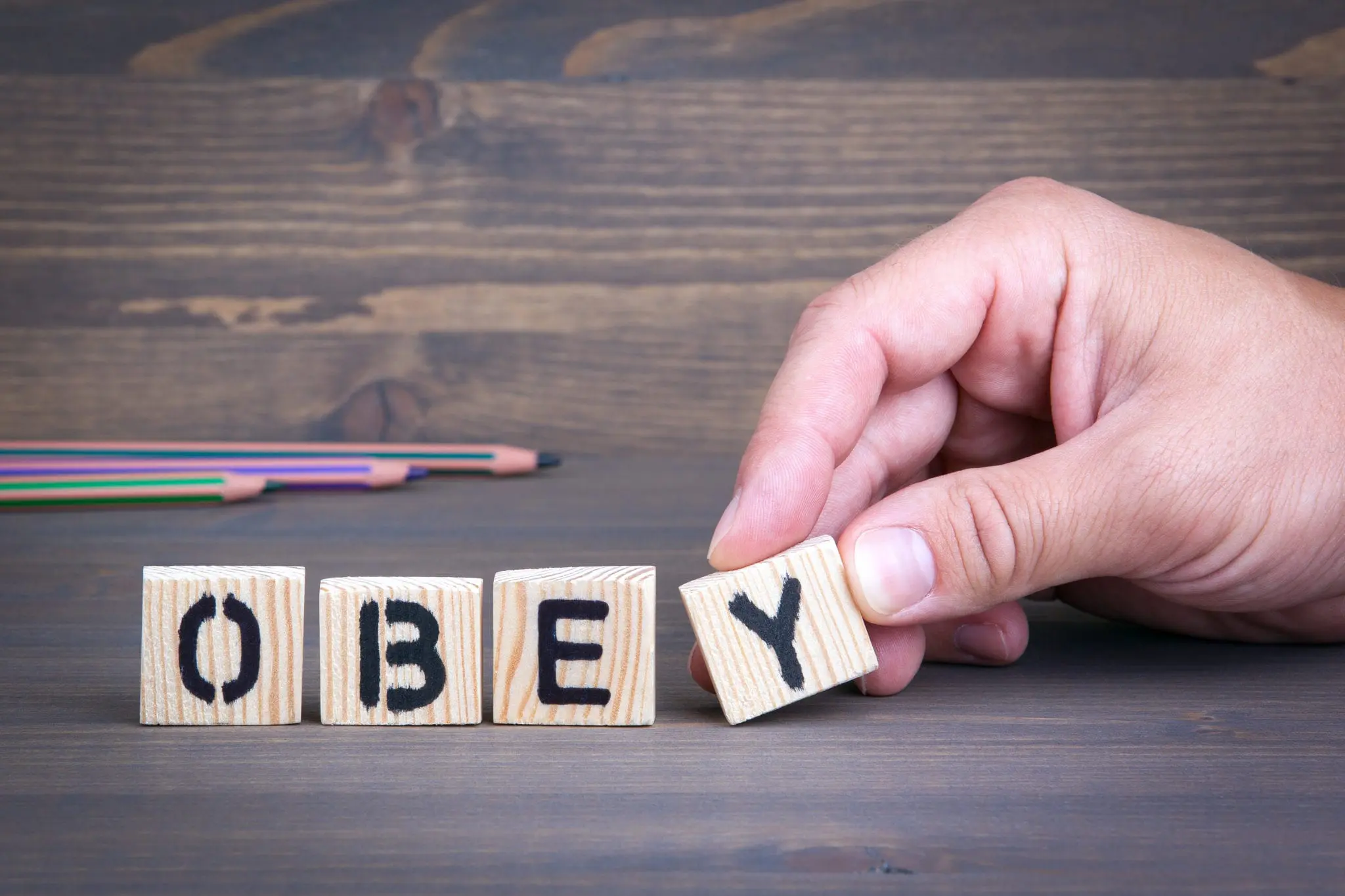 Obey from wooden letters on wooden background, relating to how we should obey God's rules