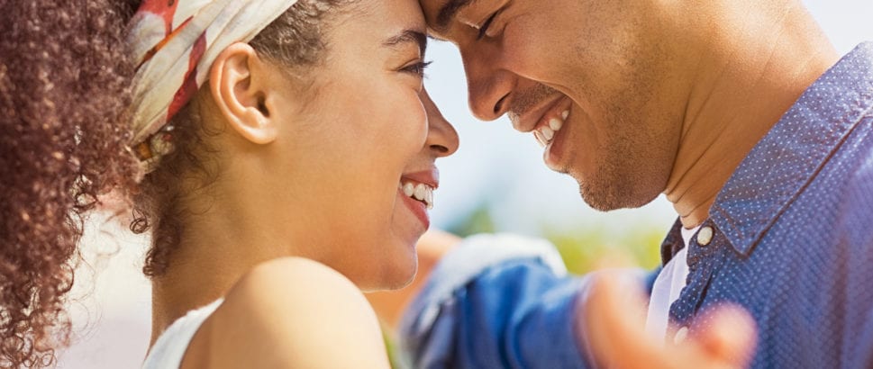 Portrait of happy young couple face to face and looking at each