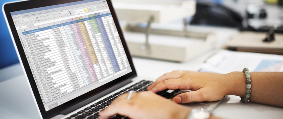 Woman typing on a computer creating a budget